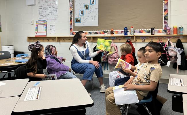 Students reading with a teacher