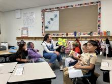 Students reading with a teacher