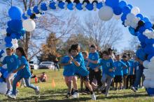 Panther Prowl event with kids running through balloon arch