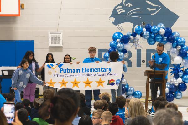 5th graders holding banner for Centers of Excellence Award